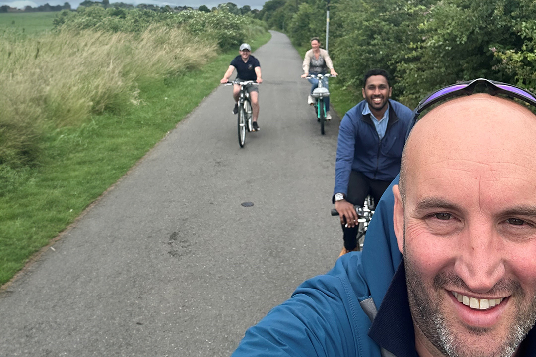 Work colleagues cycling together and smiling
